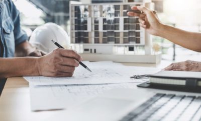 cropped-image-architects-discussing-blueprint-by-model-building-office-1024x683-1